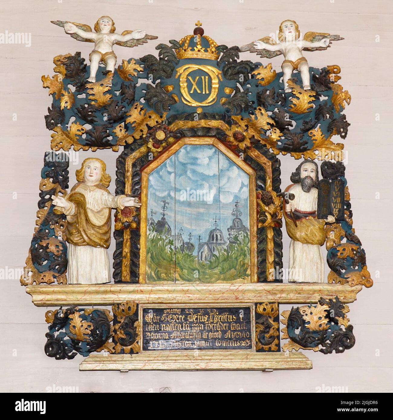 Altartavla en bois sculpté et peint. La pièce centrale: Le Sauveur sur la Croix, figure librement debout devant un fond peint, paysage, entouré par un cadre de feuillage et de fleurs. Au sommet du feuillage riche, en continu vers le bas sur les côtés. Au sommet du feuillage, le nom de Carl XII est chiffré sous la couronne royale. À la fin des côtés des images indépendantes représentant la loi et les ospels. Tout dormant dans les moulures. Predellan est une peinture avec l'inscription suivante: 'Mathj 26.v.26. (20 ?) Jésus Christ dans la nuit obtenir il trahi Wart. Thenna altarffla est Giord in Banque D'Images