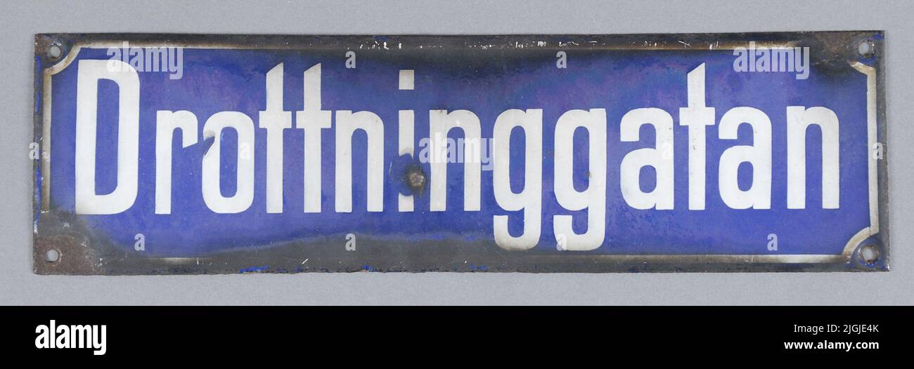 Panneau de Gatoskylt, panneau de rue de tôle. Rectangulaire, émaillé. Bleu avec cadre blanc et texte 'Drottninggatan'. Quatre trous pour le montage.rost arrière et bords. Dégâts d'émail dans trois coins, et au milieu du temps, inventaire, 1963-12. Banque D'Images
