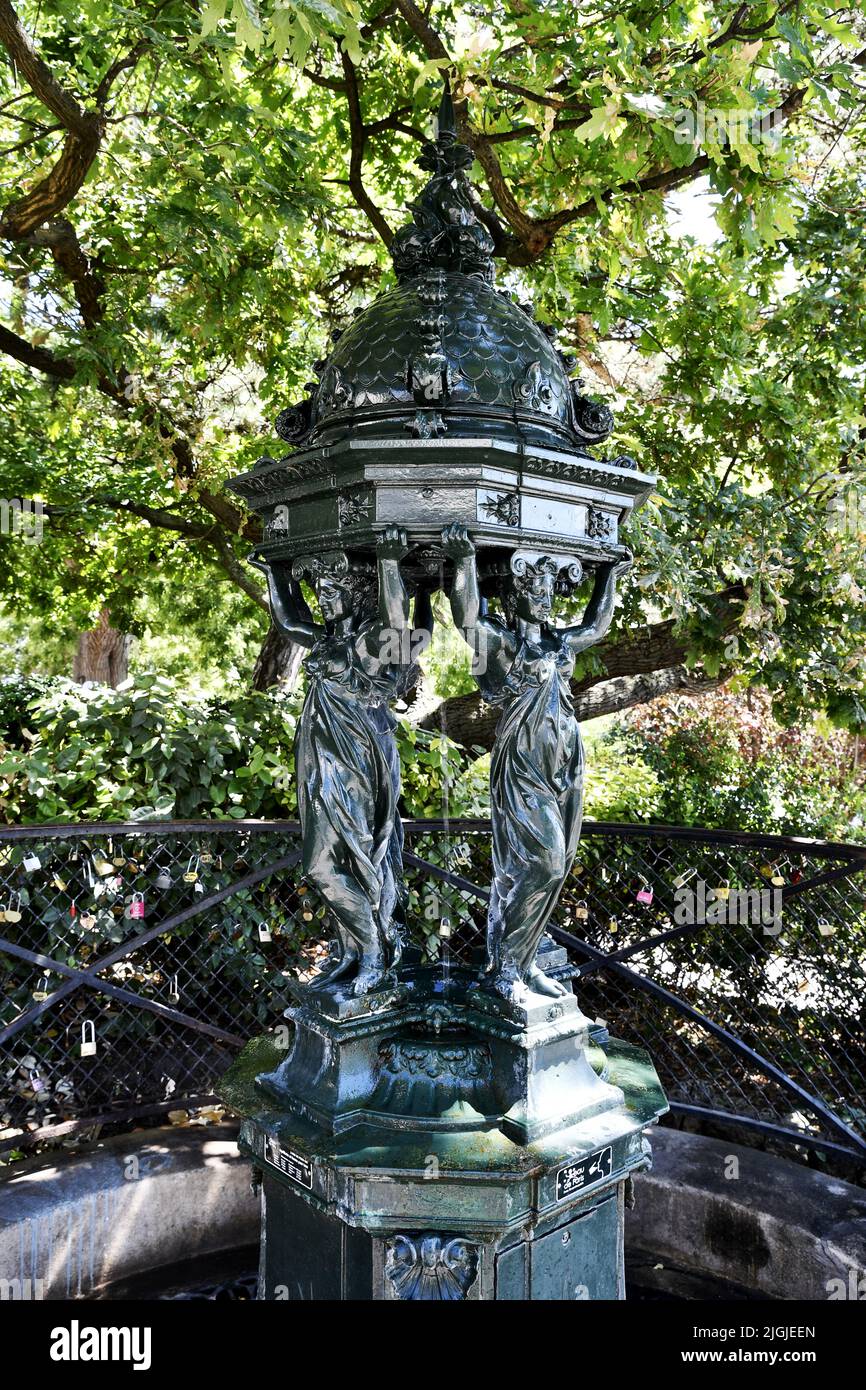 une fontaine Wallace classique vert foncé à Paris, présentant quatre figures de cariatides soutenant le dôme Banque D'Images
