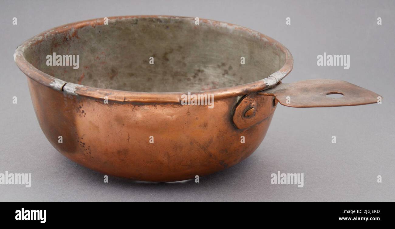 Skål bol rond en cuivre avec poignée. Intérieur, étain. Petits trous dans la partie inférieure. Quatre fissures autour du bord. Banque D'Images