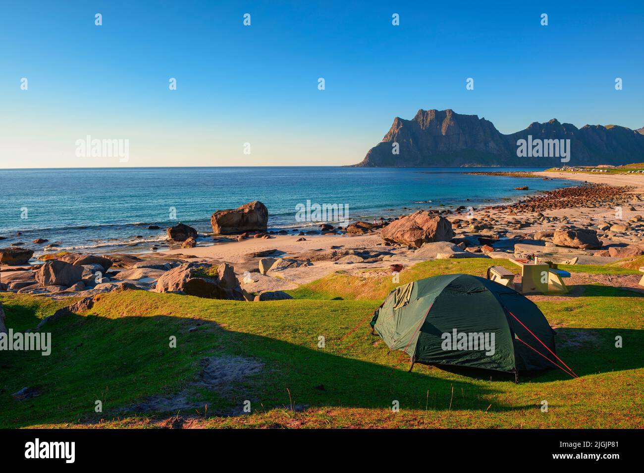 Camping au coucher du soleil avec une tente sur la plage d'Uttakleiv dans les îles Lofoten, Norvège Banque D'Images