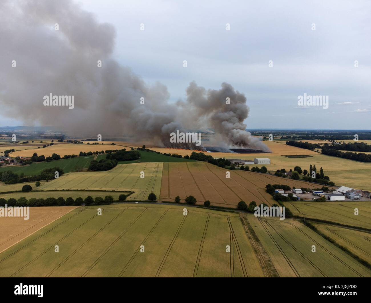 Ripon, North Yorkshire, Royaume-Uni. 11th juillet 2022. La fumée et les flammes remplissent l'air dans ce feu de champ pendant l'été chaud. L'incendie sur les terres agricoles près de Ripon a été causé par une moissonneuse-batteuse qui a pris feu et s'est propagée à la récolte en cours de récolte. Banque D'Images