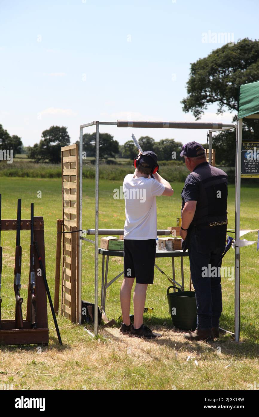 The Royal Cheshire County Show, Knutsford, Angleterre, Royaume-Uni. - 22 juin 2022: Un jeune homme instruit en tir de pigeon d'argile sur la plage de tir. Banque D'Images