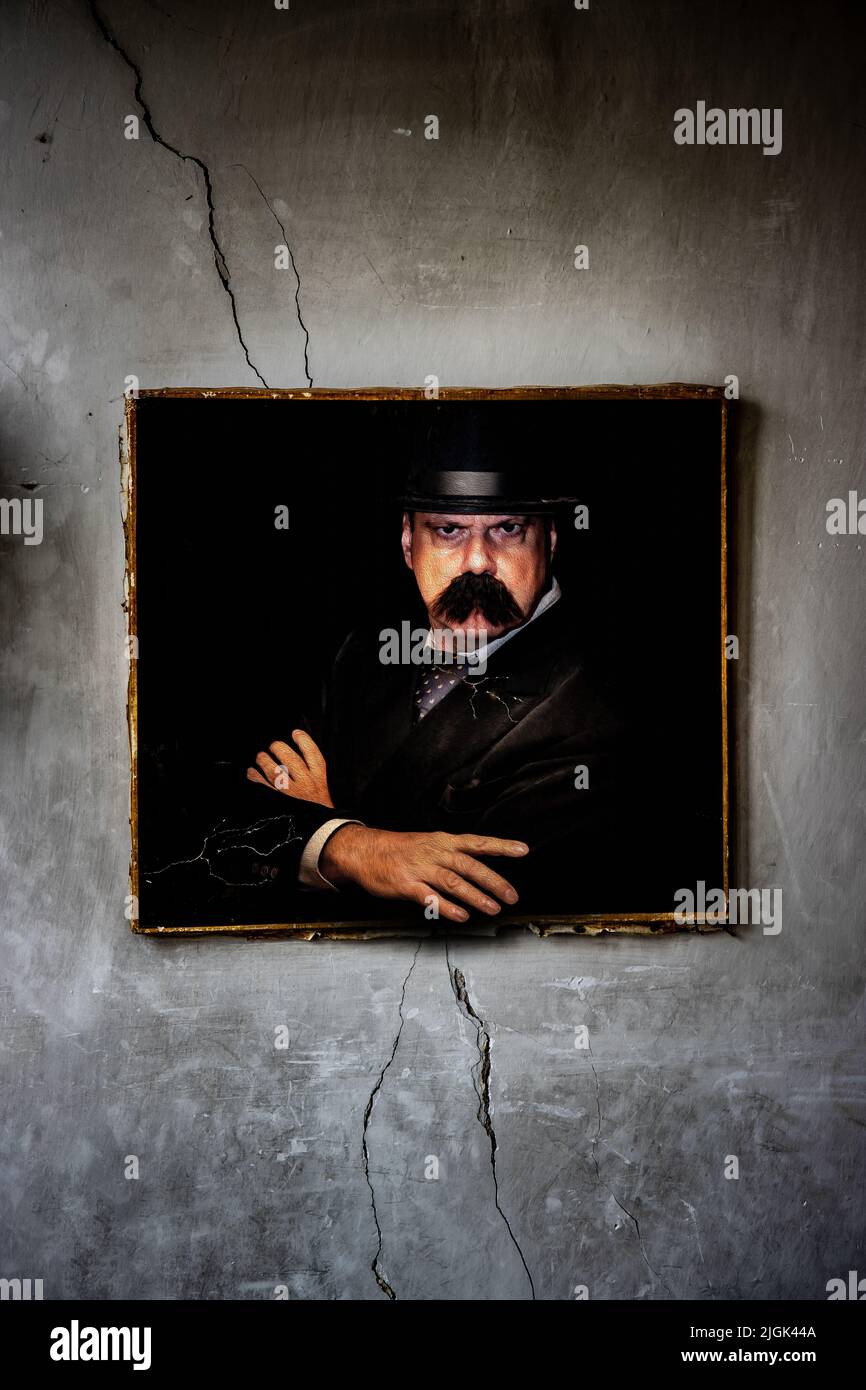 Une peinture d'un homme avec une moustache est accrochée à un mur brisé Banque D'Images