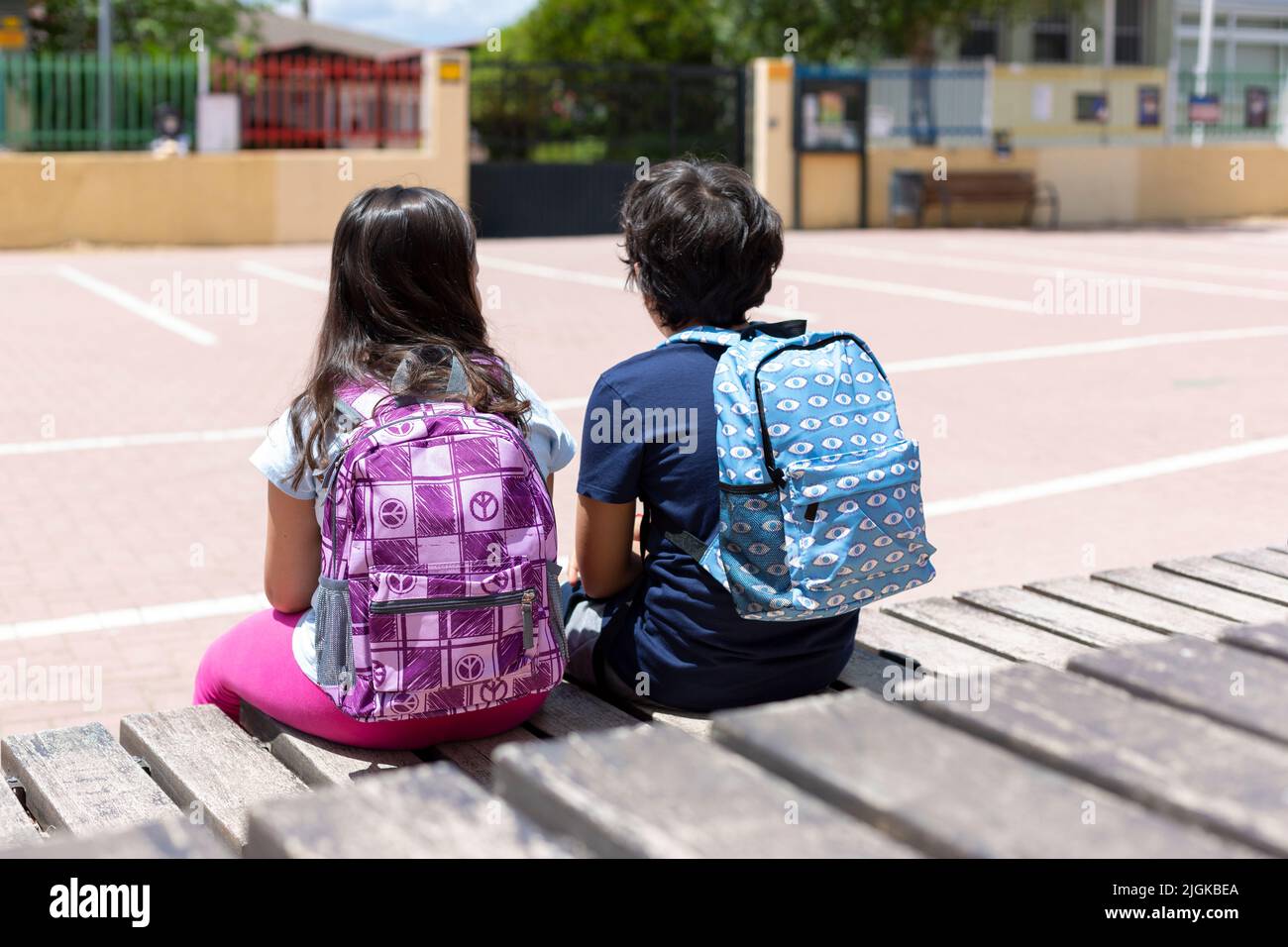Vue arrière de deux jeunes enfants élèves avec leur sac à dos à l'entrée de l'école. Concept de retour à l'école. Espace pour le texte. Banque D'Images