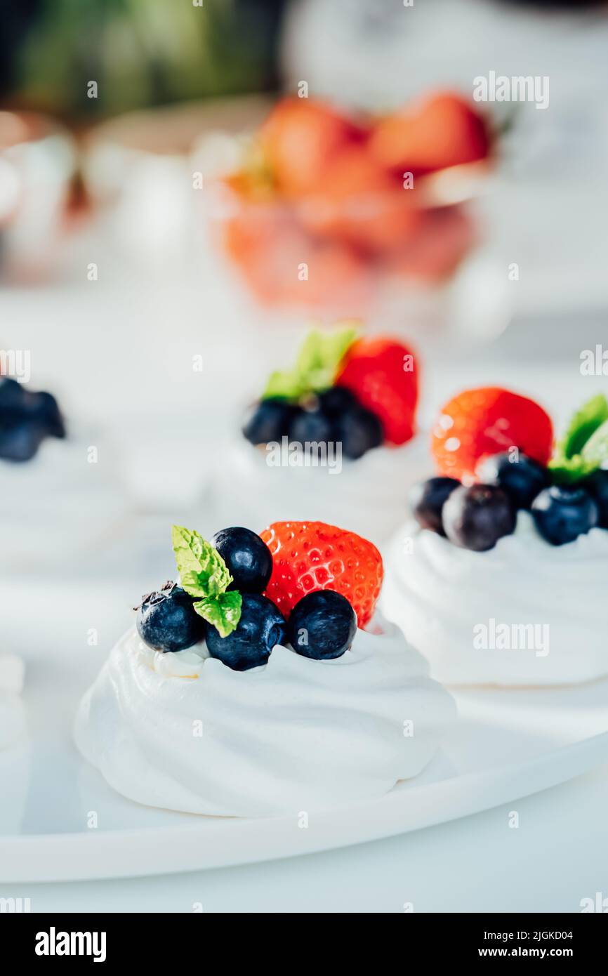 Dessert meringue gâteau Pavlova à la crème fraîche, aux fraises et aux myrtilles, décoré de menthe sur la plaque blanche. Recettes pour de délicieux repas légers Banque D'Images Dessert meringue gâteau Pavlova à la crème fraîche, aux fraises et aux myrtilles, décoré de menthe sur la plaque blanche. Recettes pour de délicieux repas légers Banque D'Images