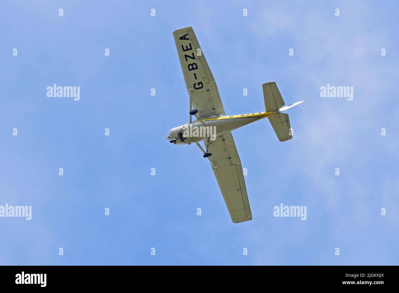 Cessna A152 Aerobal G-BZEA survolant un ciel bleu. Banque D'Images