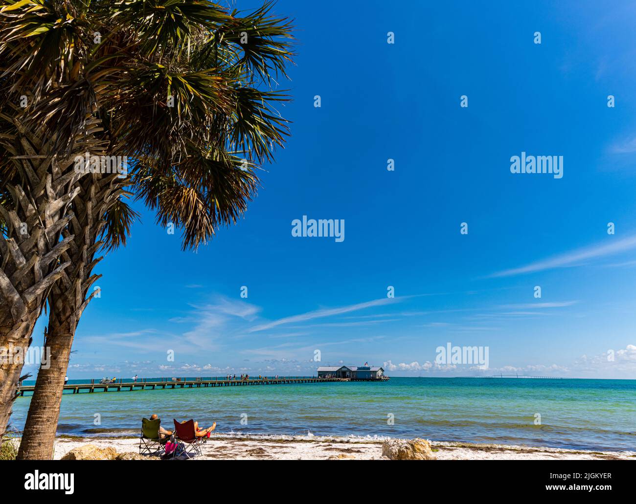 Bains de soleil sur la plage avec Amelia Island Pier au loin, Amelia Island, Floride, États-Unis Banque D'Images