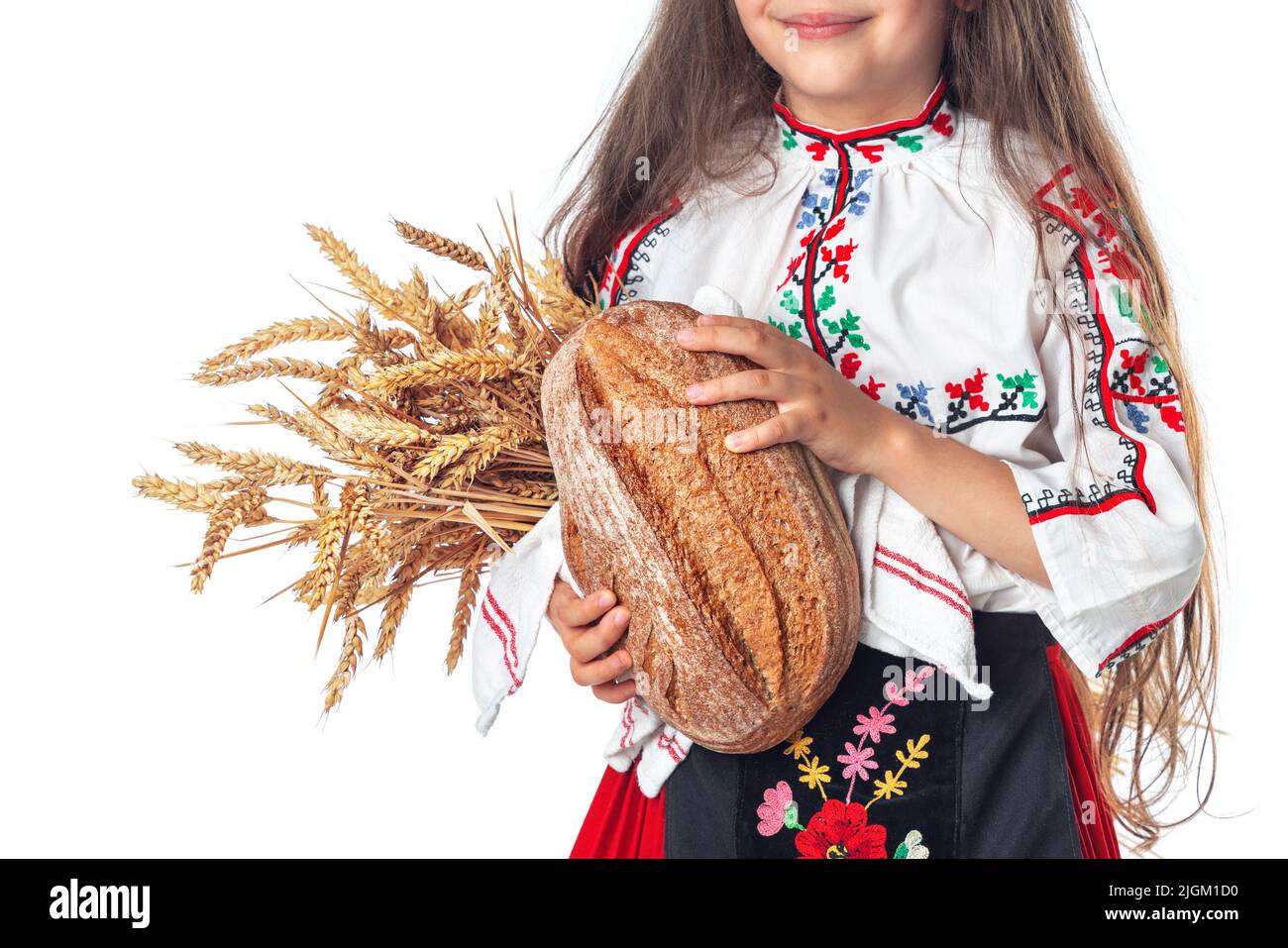 Portrait d'une belle fille en robe traditionnelle bulgare folklorique tenant du pain fait maison et du blé doré Banque D'Images