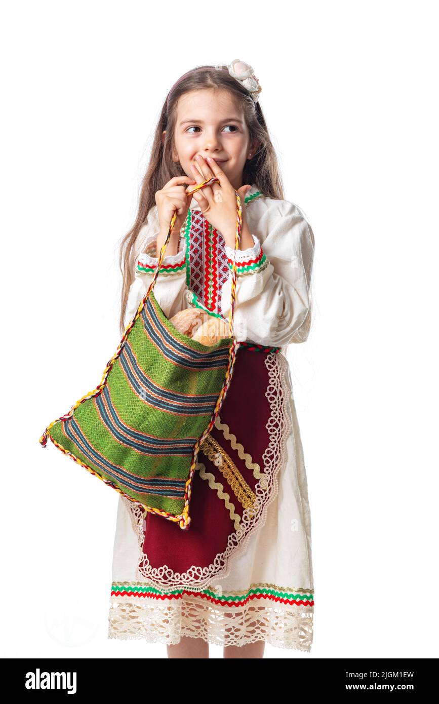 Une femme bulgare ou une jeune fille en robe traditionnelle folklorique tient dans les mains du blé doré et du pain maison fraîchement cuit dans un sac Banque D'Images