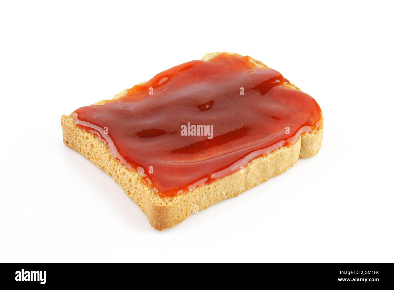 Confiture rouge sucrée sur pain grillé isolé sur fond blanc. Marmelade brillante Banque D'Images