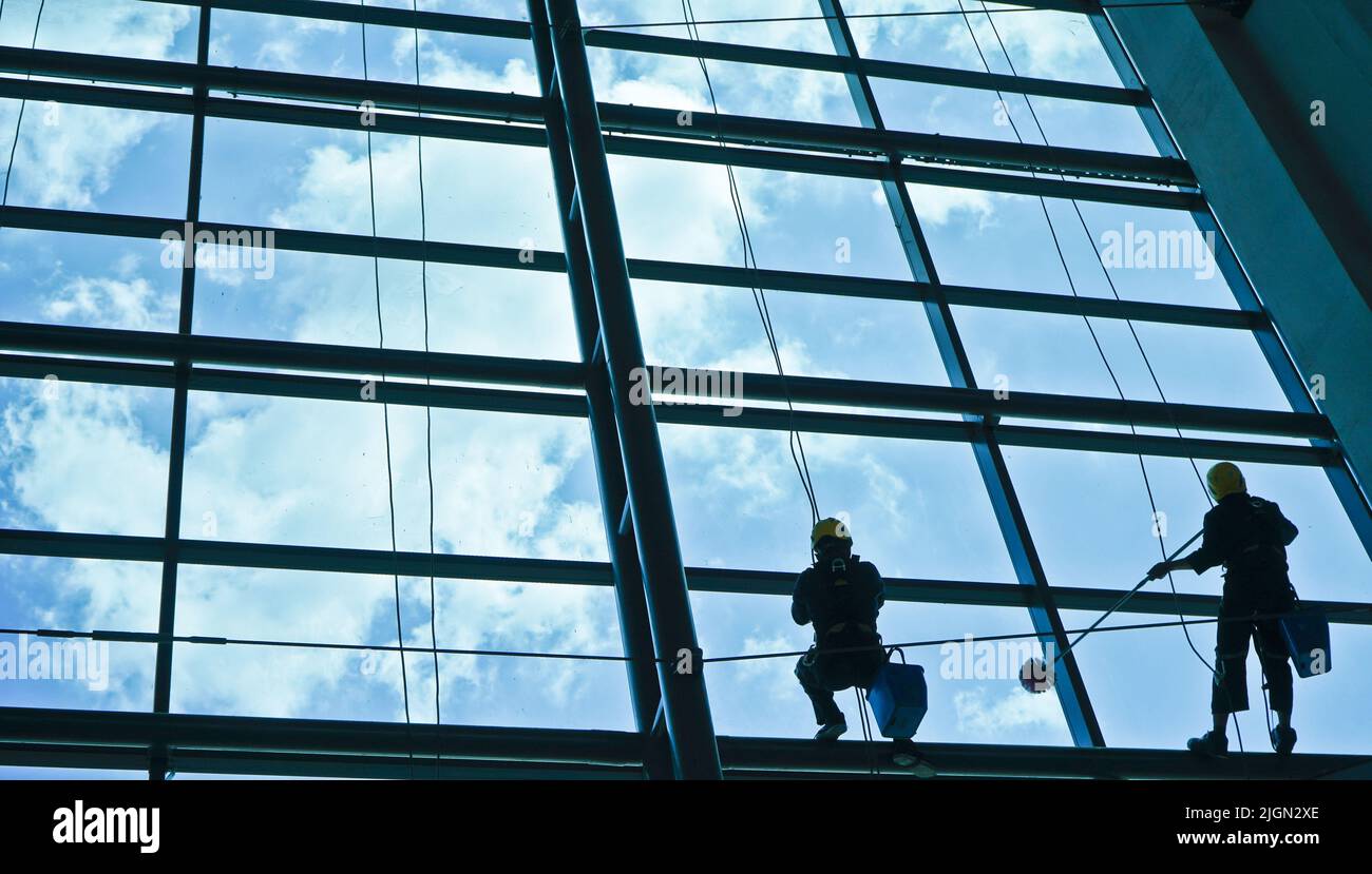 Travail extrême. Le nettoyage du verre d'un bâtiment à une hauteur élevée prend du courage et défie l'adrénaline Banque D'Images