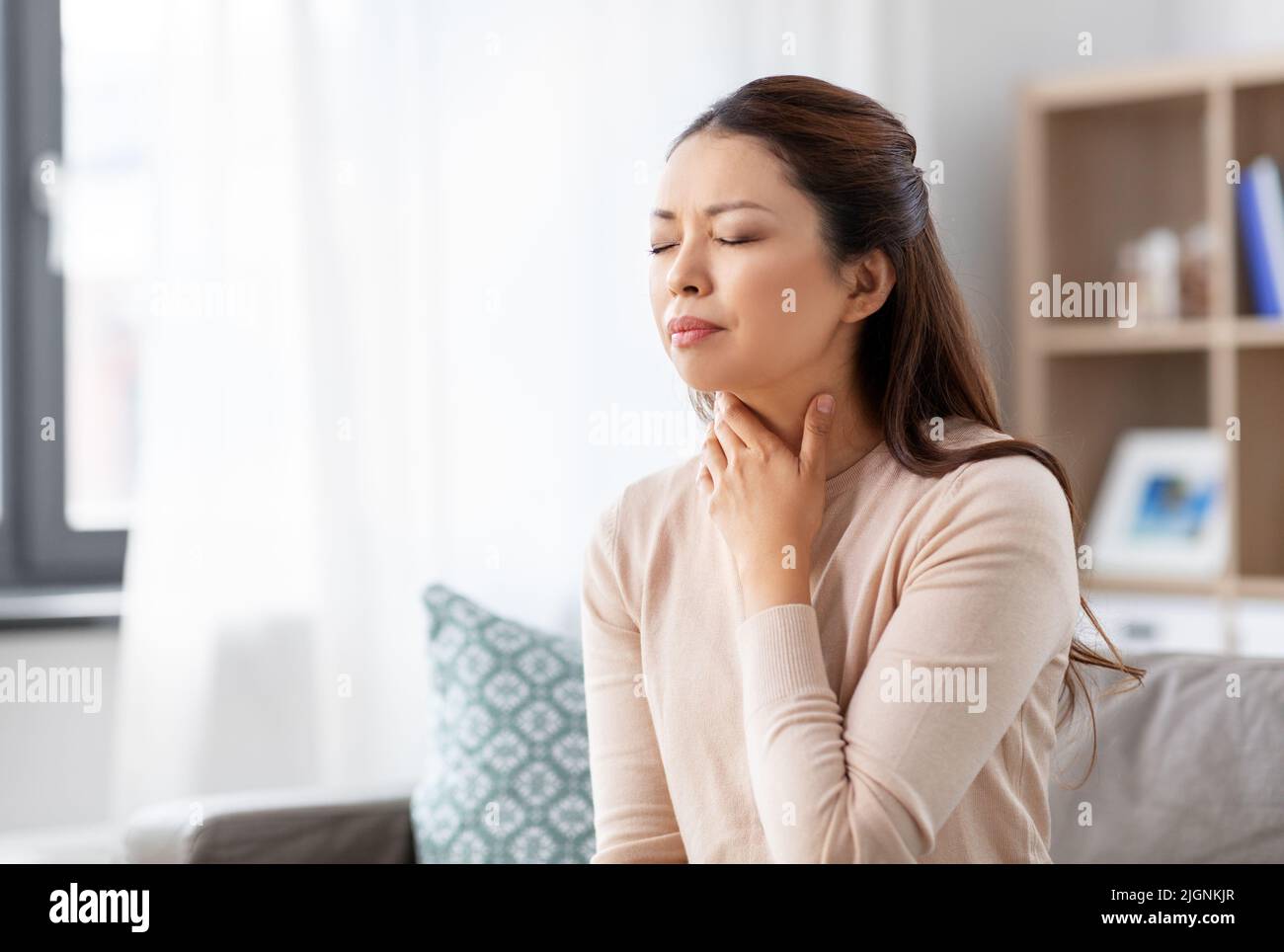 femme asiatique malade avec mal de gorge à la maison Banque D'Images