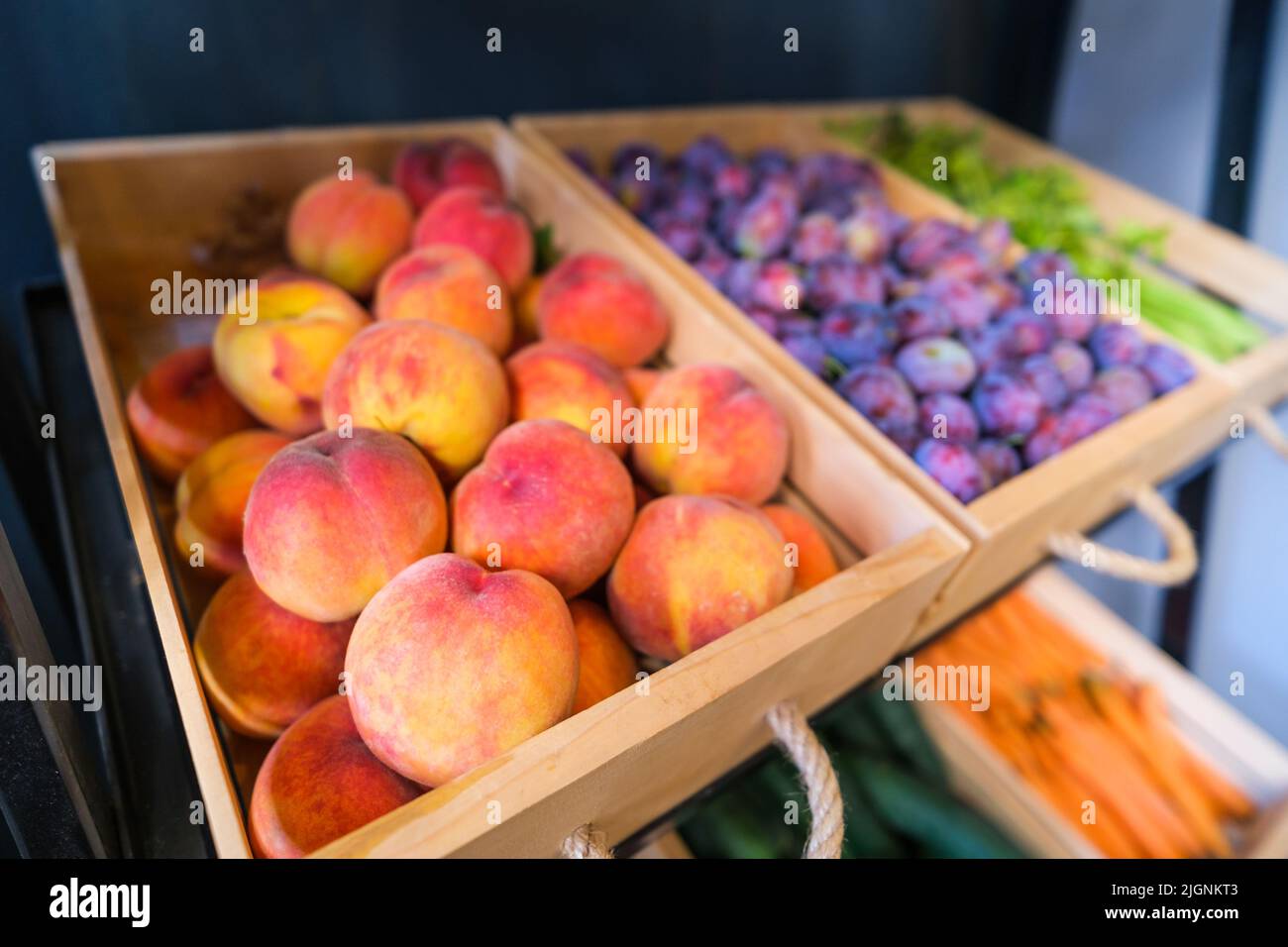 Fruits et légumes sains dans l'épicerie. Gros plan du panier avec des pêches au supermarché. Banque D'Images