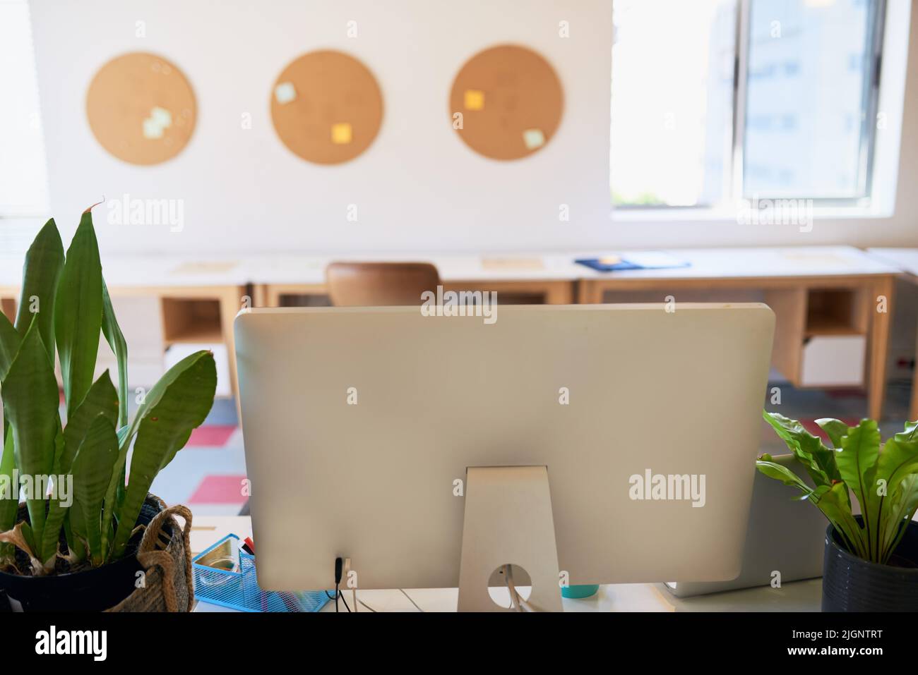 Un bureau créatif vide avec un grand écran d'ordinateur sur le bureau Banque D'Images