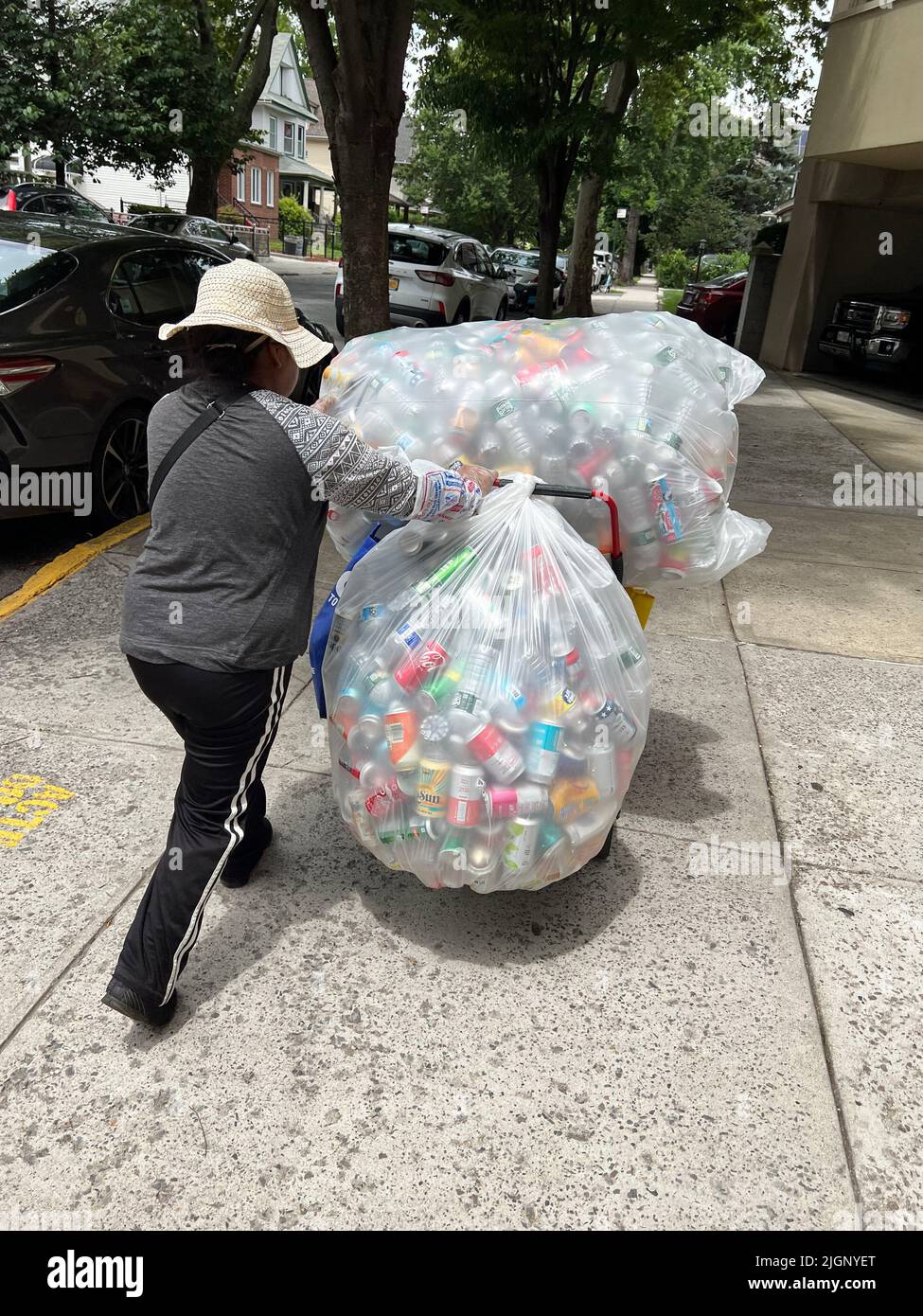 Collecteur de canettes et de bouteilles en aluminium dans un quartier résidentiel de Brooklyn, New York. Banque D'Images