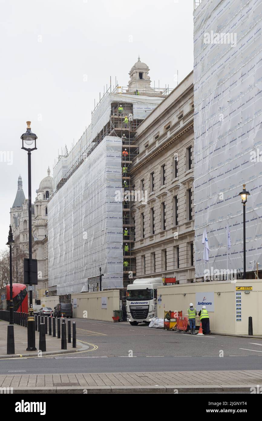 Ouvriers de la construction passant des poteaux d'échafaudage vers le haut, Londres, Royaume-Uni Banque D'Images
