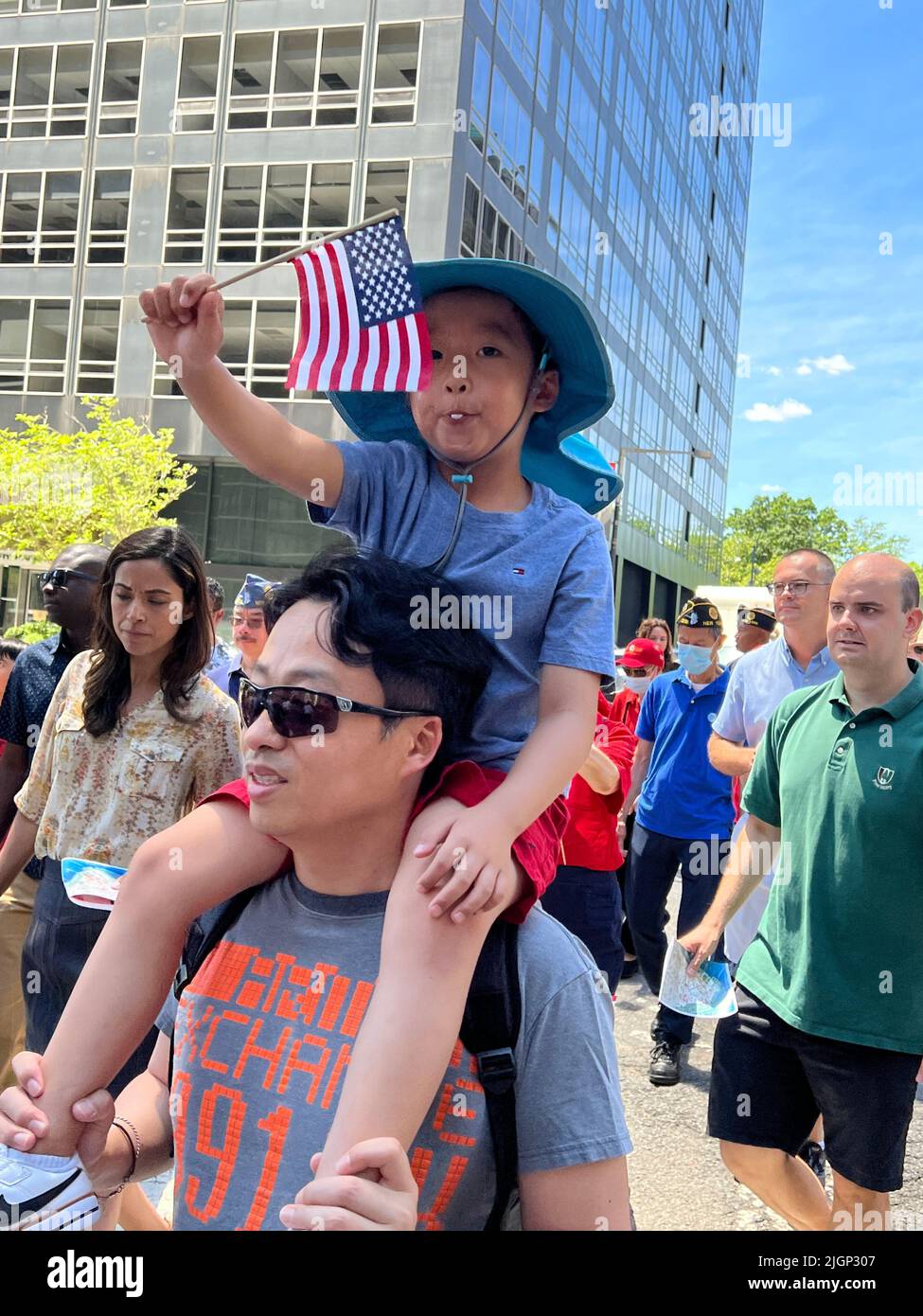 Petit défilé du jour de l'indépendance le 4 juillet dans le centre historique de Manhattan où George Washington a prêté le premier serment présidentiel. Père et petit fils asiatiques américains marchent dans le défilé. Banque D'Images