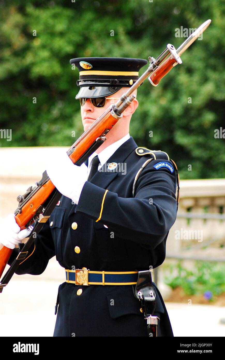 Un soldat de la garde d'honneur présente des armes lors de la cérémonie de la relève de la garde à la tombe du soldat inconnu du cimetière national d'Arlington Banque D'Images