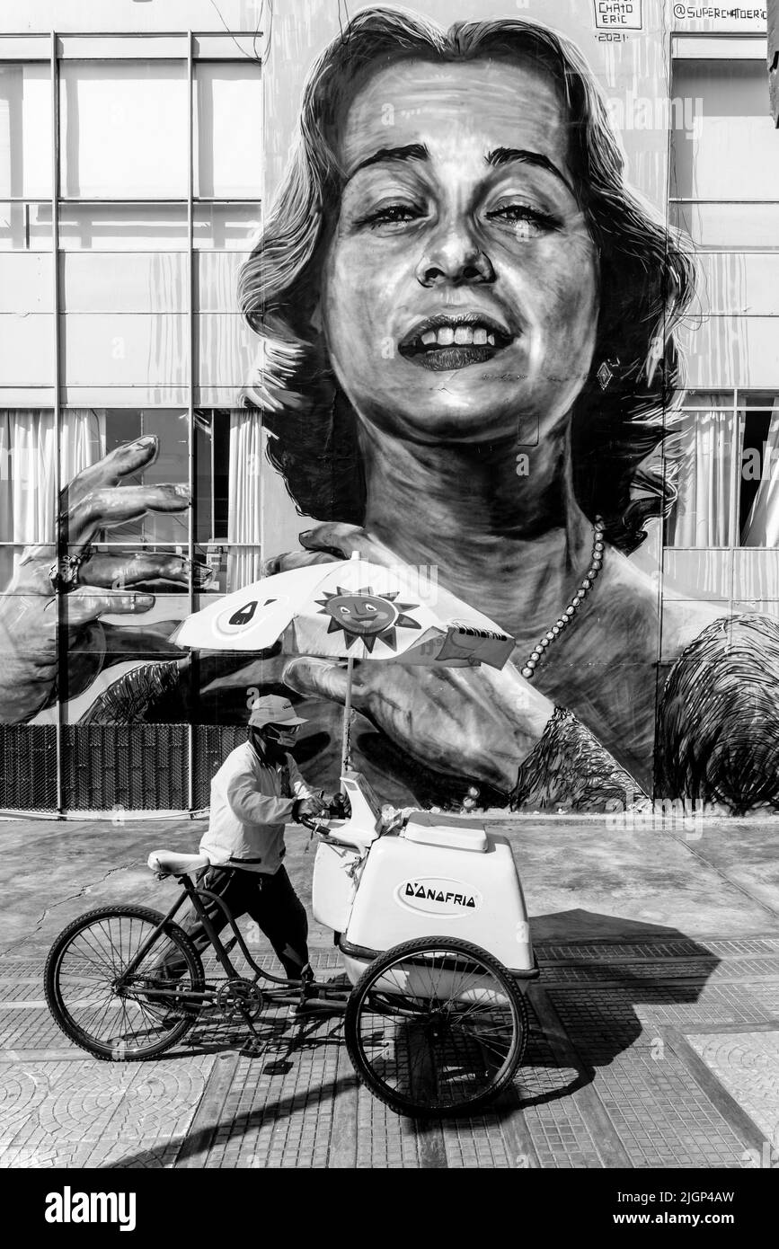 Un vendeur de crème glacée passe par Une grande murale dans le district de Barranco, Lima, Pérou. Banque D'Images
