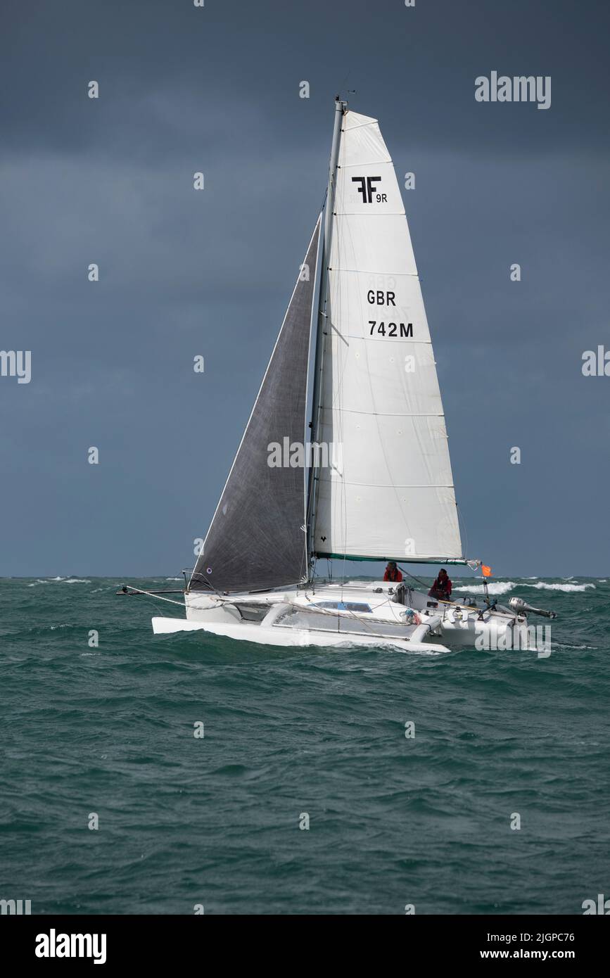 Un petit yacht trimaran courageux, Alini, sur le chemin d'un gain de classe et une superbe position 9th dans l'ensemble de la course de yacht de l'île de Wight Round the Island. Banque D'Images