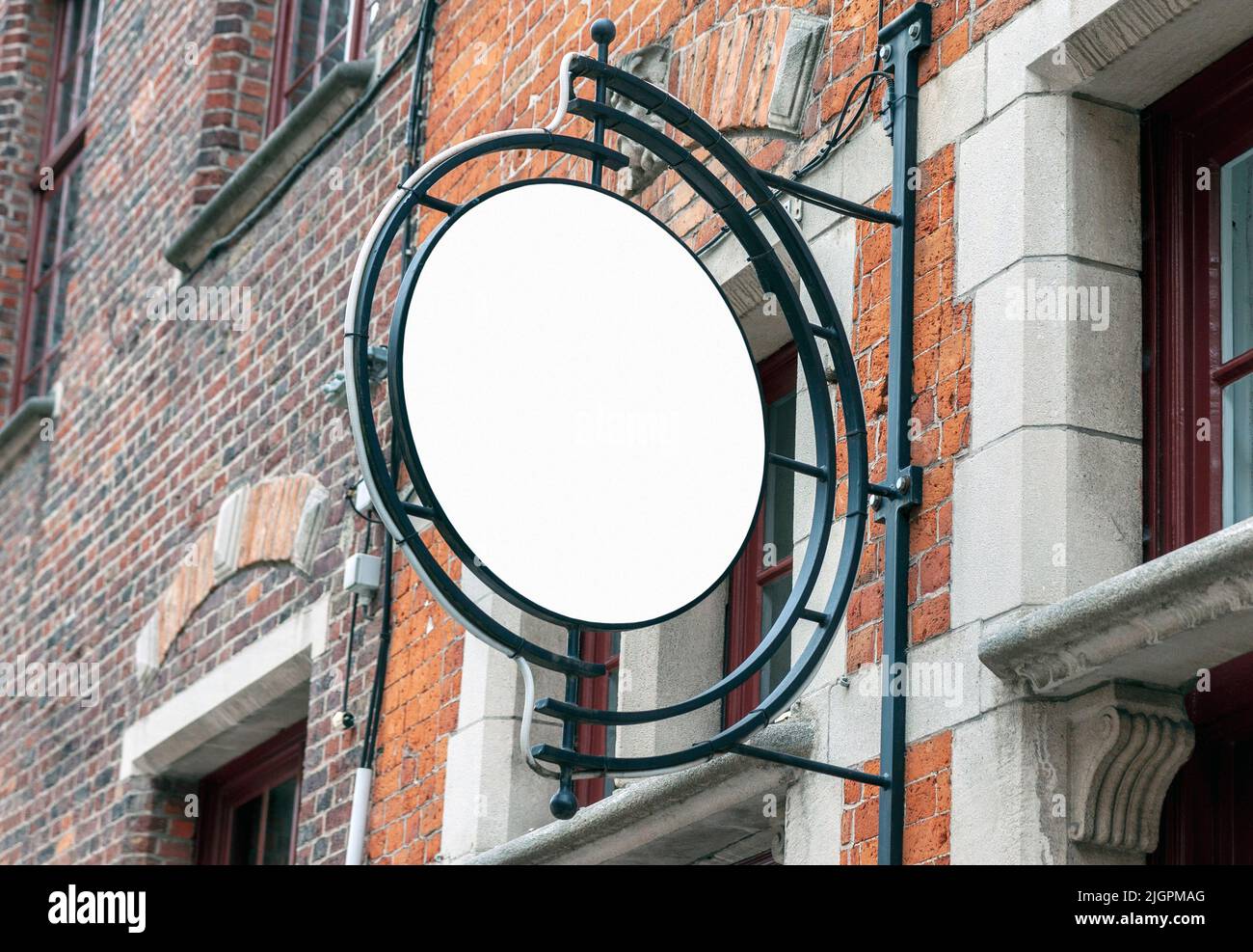 Entourez la maquette du panneau de signalisation sur le vieux mur de briques, une affiche vierge pour ajouter le logo de la société ou du restaurant Banque D'Images