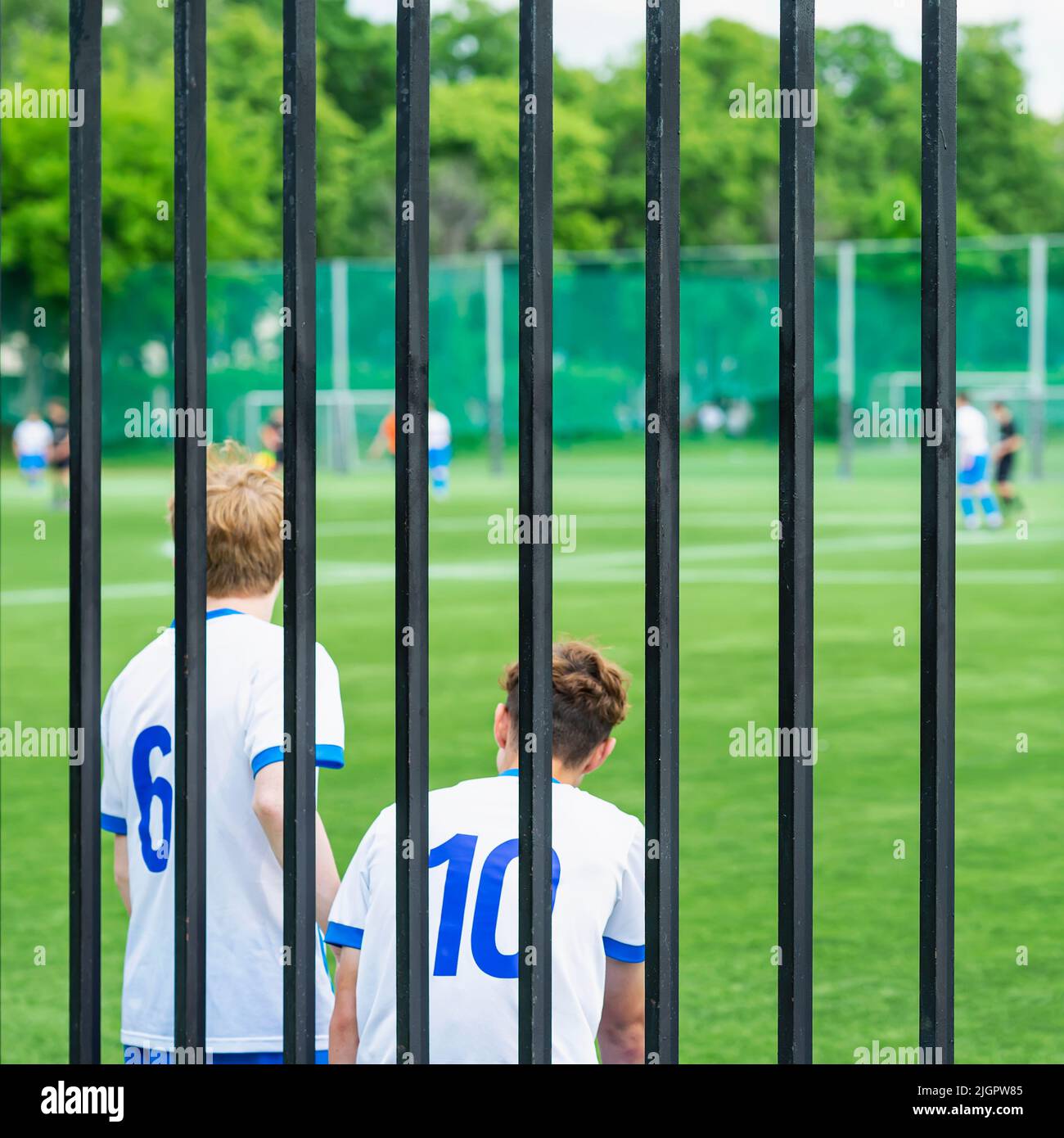 Deux jeunes garçons à côté de la clôture, joueurs de rechange, match de football, match junior Banque D'Images