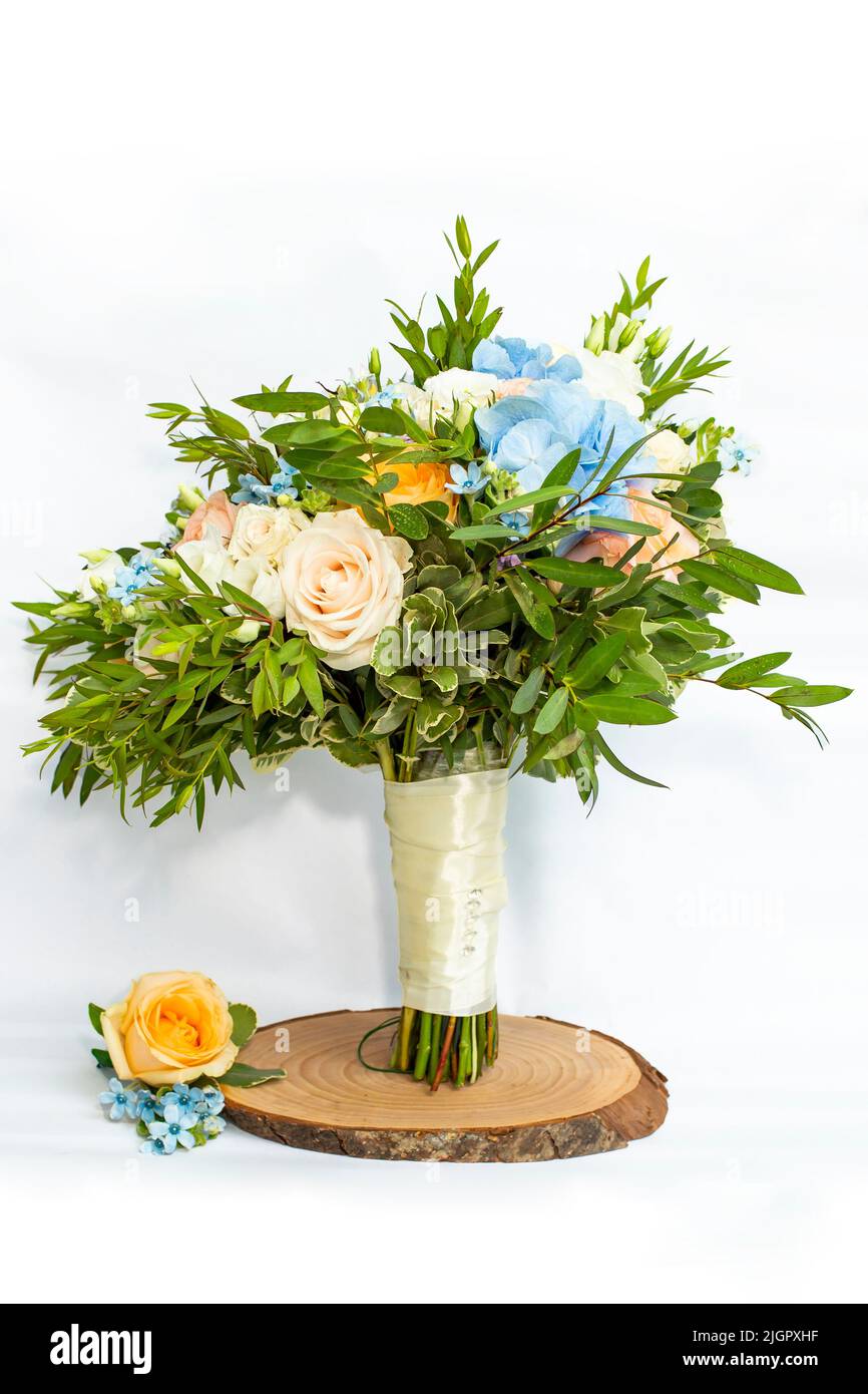 Bouquet de mariée et boutonnière assortie avec roses orange et crème et petites touches de fleurs bleues. Banque D'Images