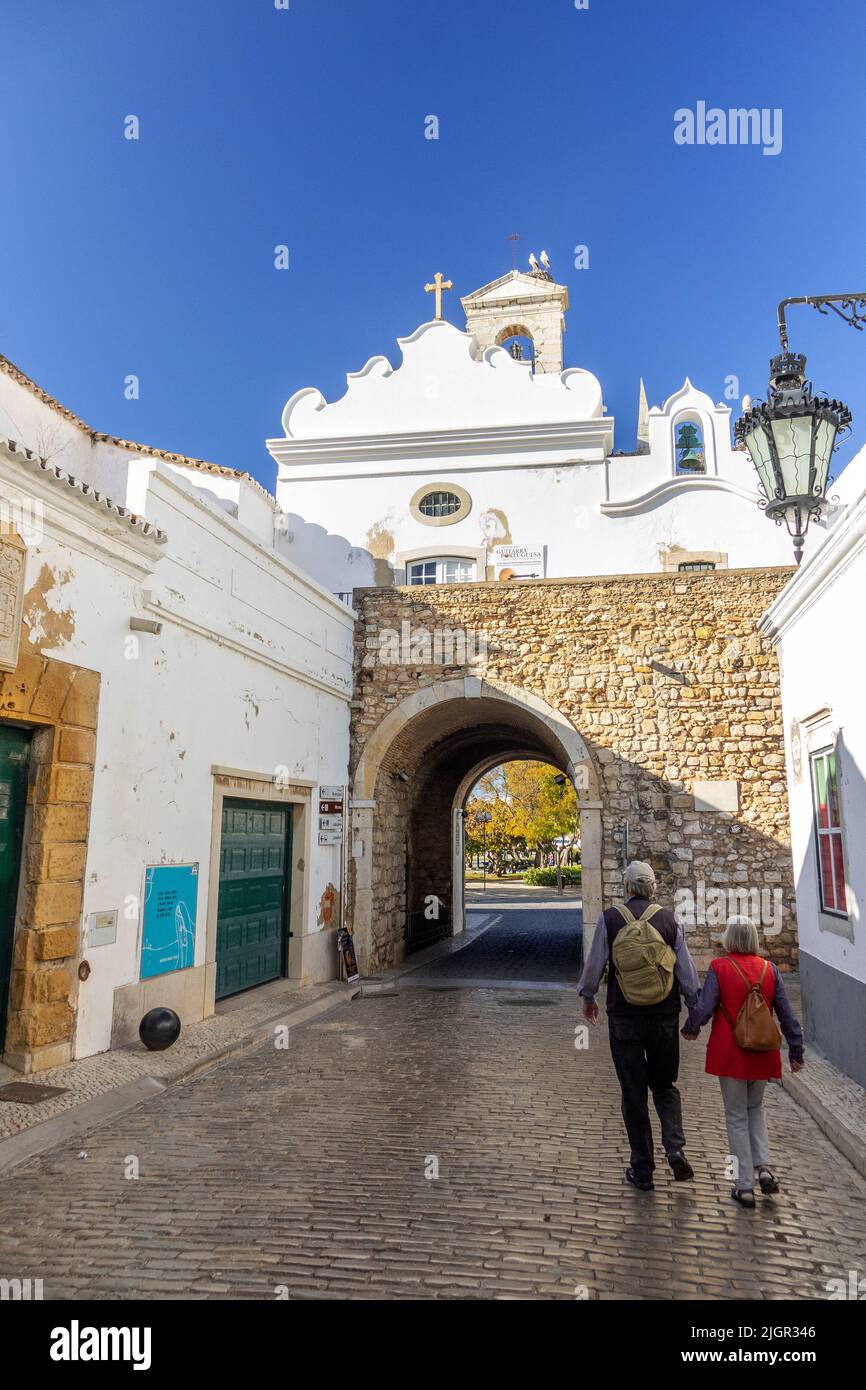 Couple touristique retraité à pied à l'Arco da Vila Faro Portugal une des portes d'origine dans la vieille ville de Faro l'Algarve Portugal, deux Storks Banque D'Images