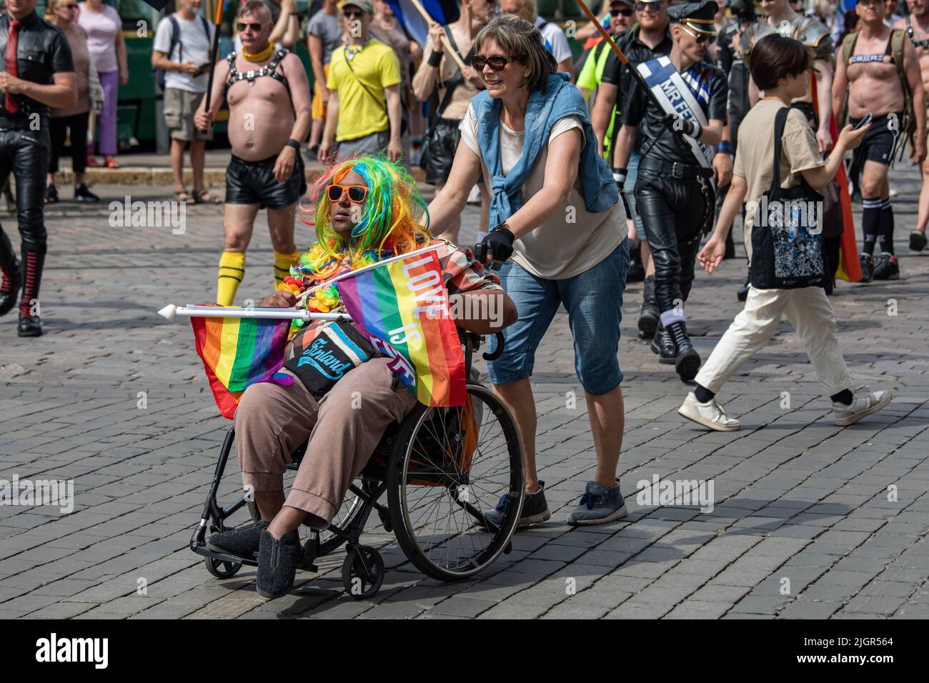 Homme en fauteuil roulant et assistant au défilé Helsinki Pride 2022 à Helsinki, Finlande Banque D'Images