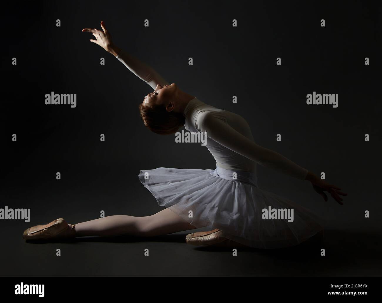 la ballerine élégante a fait une déflexion. la photo prend dans le studio sur un fond sombre. Banque D'Images