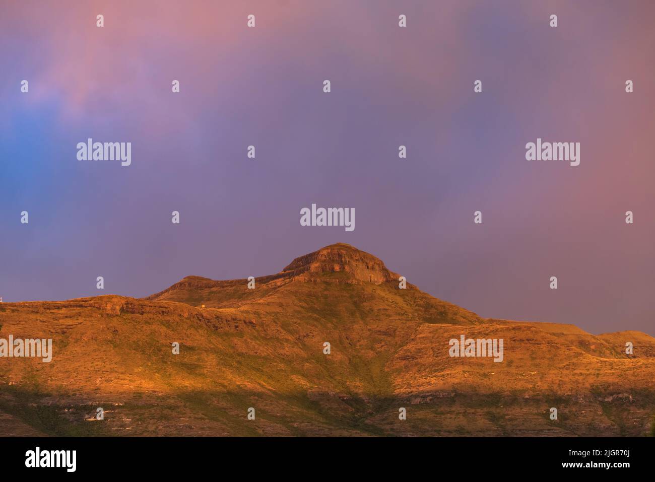 Mont Horeb à Clarens, en Afrique du Sud, éclairé en orange sous un ciel rose et violet au coucher du soleil Banque D'Images