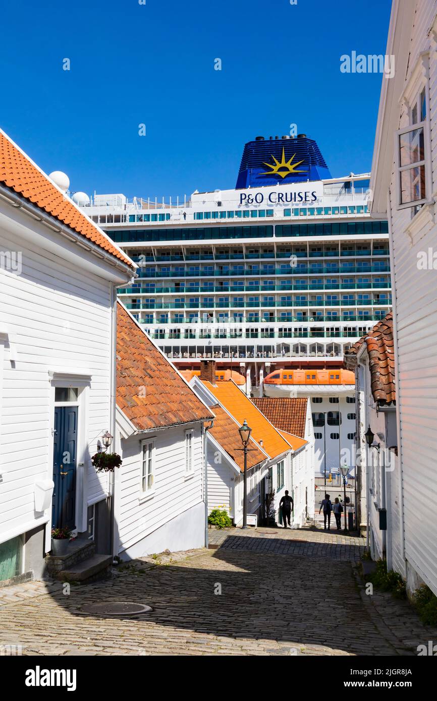 Le bateau de croisière P&O MS Iona éclipse les maisons en bois blanc de Klausegata, Stavanger, Norvège. Banque D'Images