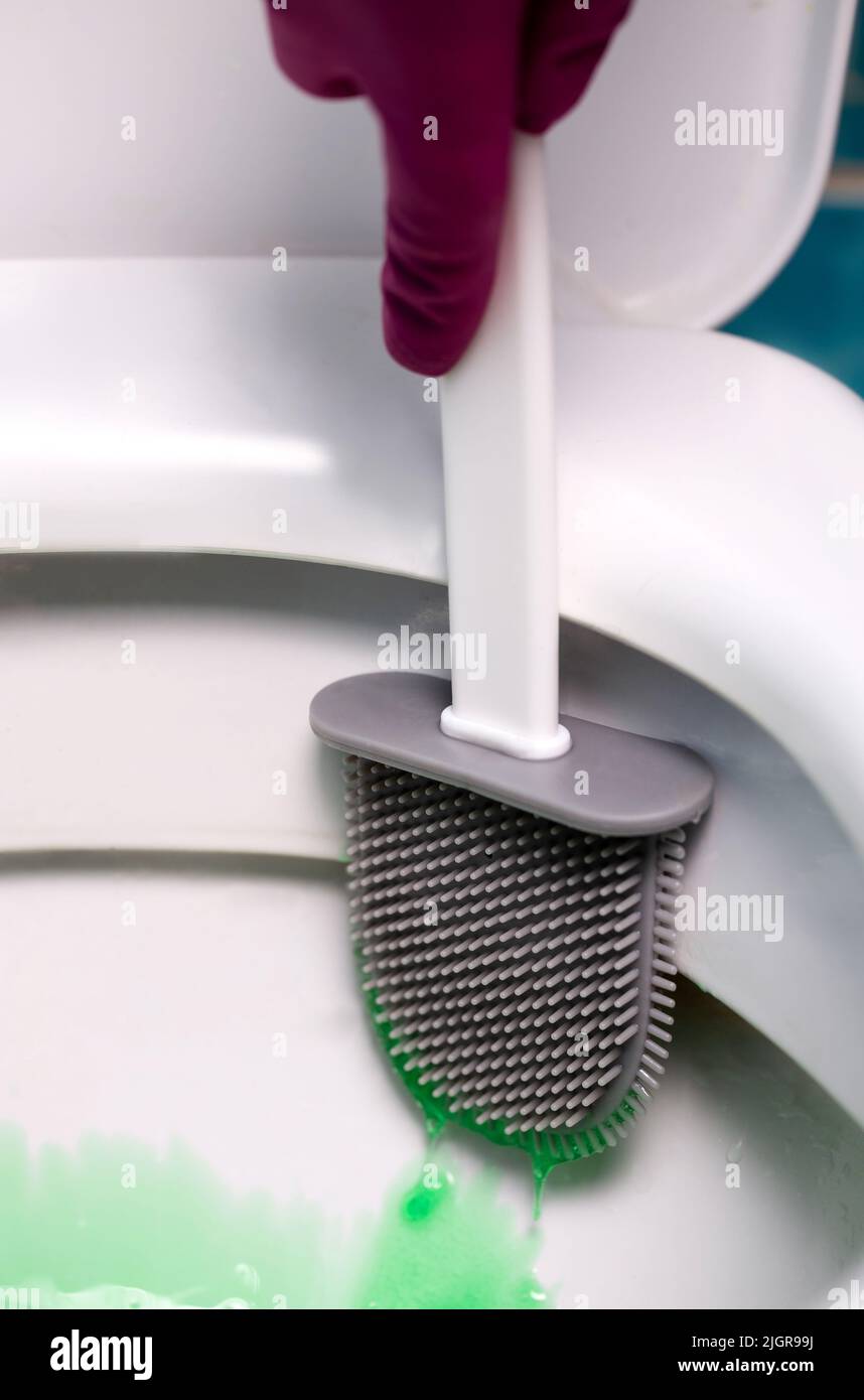 nettoyage des toilettes à l'aide d'une brosse en silicone. Banque D'Images