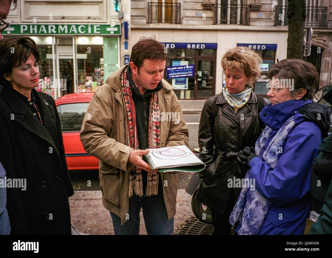 Un guide à pied parisien explique l'itinéraire que ses clients emprunteront. Banque D'Images