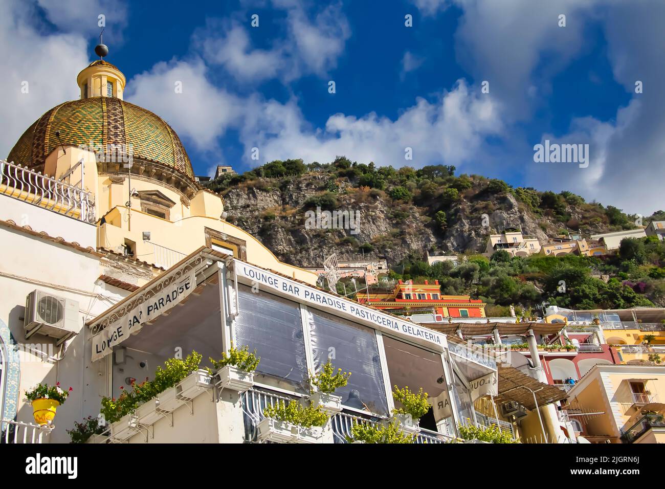 Le Santa Maria Assunta Croch et un bar-salon contre la montagne et ciel bleu nuageux à Positano, Italie Banque D'Images