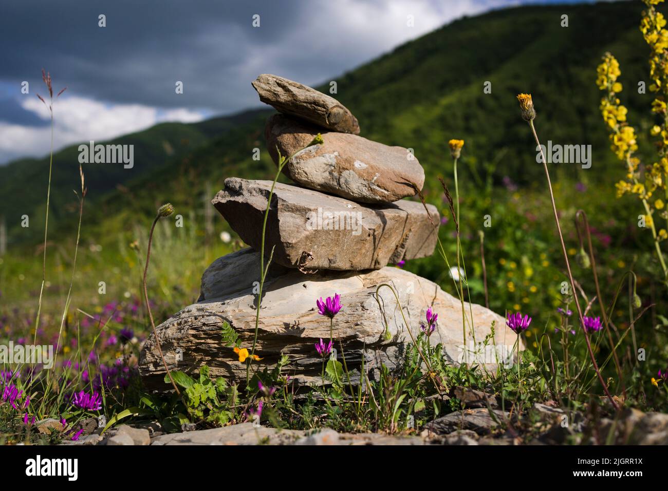 Pile de pierres avec des pierres équilibrées sur fond de montagne flou Banque D'Images