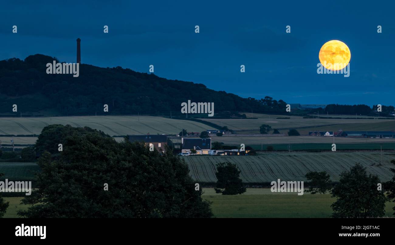 East Lothian, Écosse, Royaume-Uni, 12th juillet 2022. Météo au Royaume-Uni : Buck supermoon : la dernière super lune de cette année est la pleine lune de juillet appelée Buck Moon, vue à côté du monument victorien sur la colline de Byres Hill. La lune est à 98,7% de sa taille maximale Banque D'Images