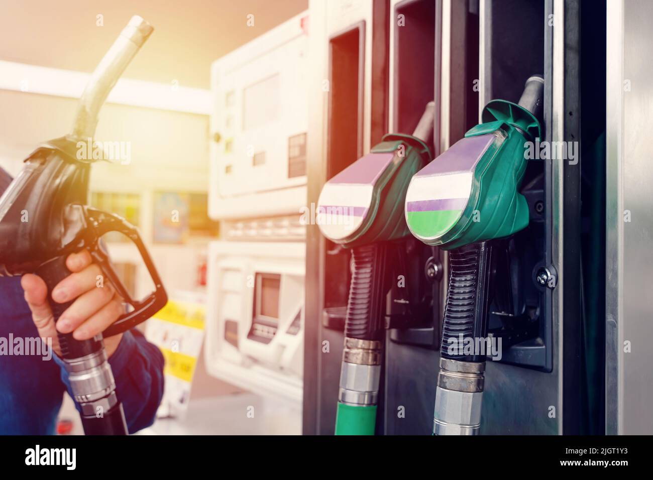 Un homme à la station-service remplissant le réservoir de sa voiture avec du diesel au niveau supérieur avant un long voyage que le prix du carburant augmente Banque D'Images