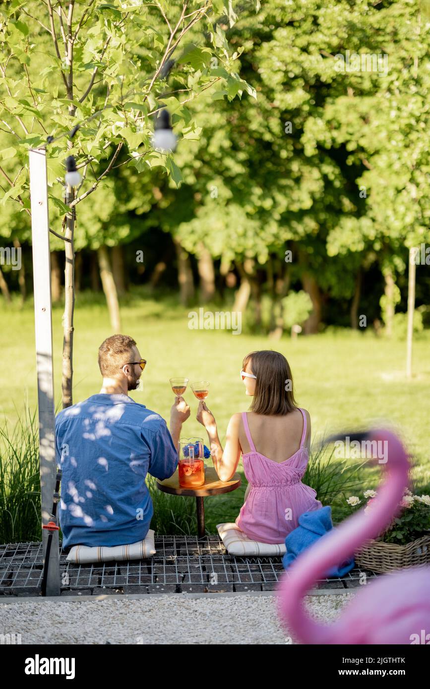 Un jeune couple passe l'été avec un verre sur la nature Banque D'Images