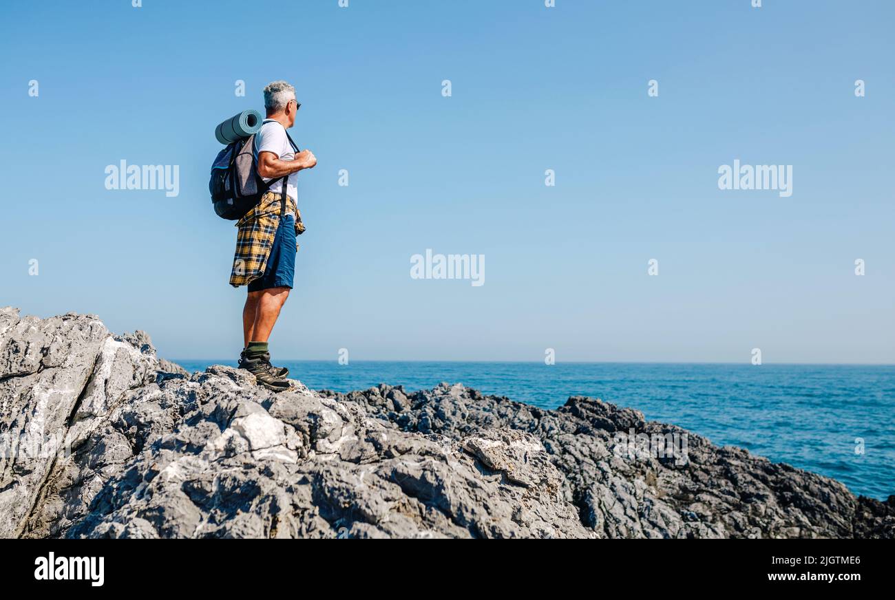 Homme de randonnée senior regardant le paysage de la mer Banque D'Images