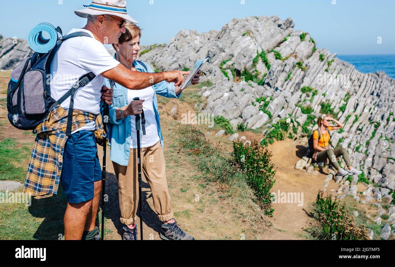 Randonnée senior couple regardant la carte dans le paysage rocheux Banque D'Images