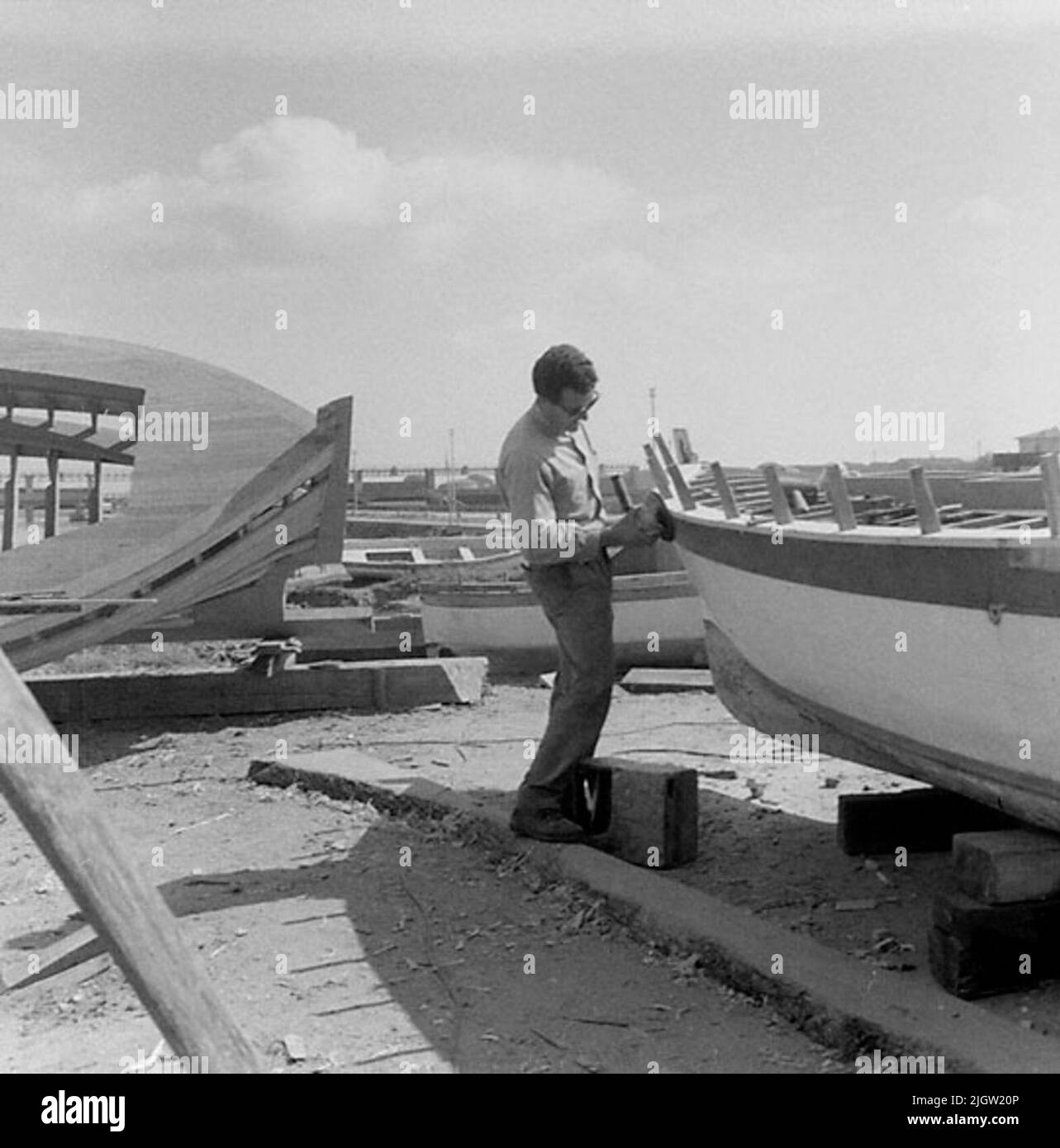 Collection de 9 photos. Un homme meule sur la rampe à un petit bateau de pêche. Banque D'Images