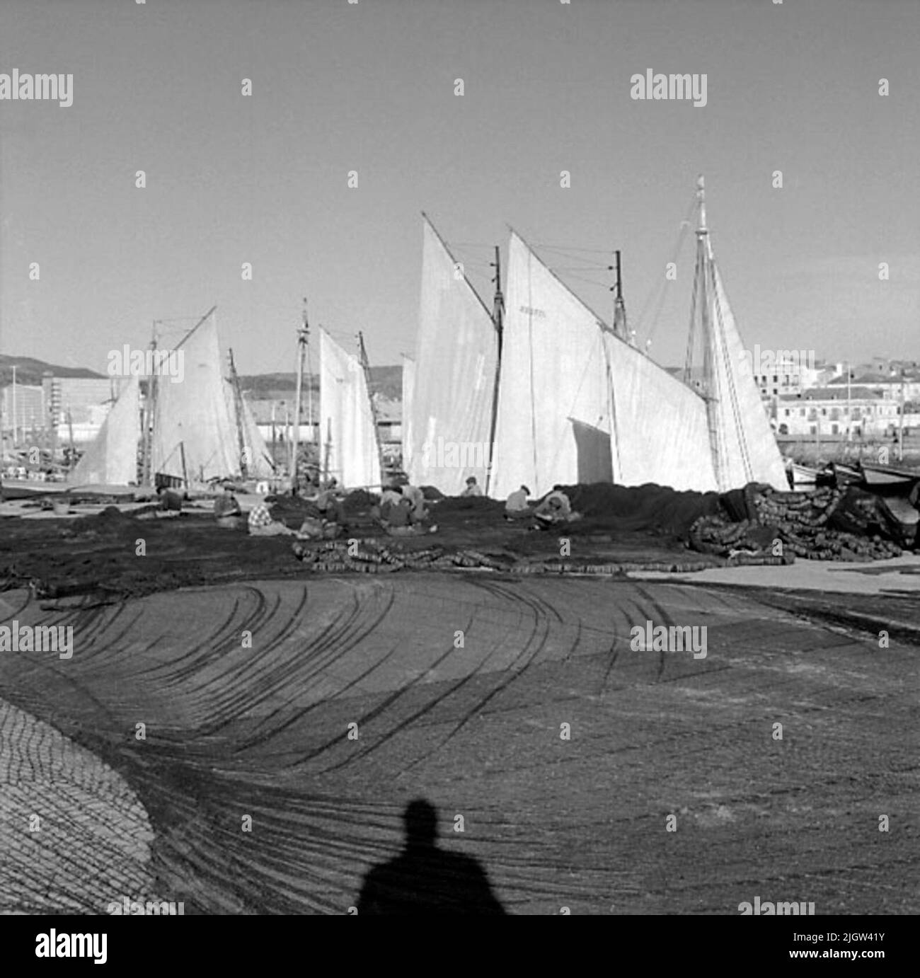 46. Portugal. Le journal photo est disponible à B.M.A. + albums photo. Acquisition : livres et documents d'archives. Photos prises 1959-11-15,12 photos en série. Selon les notes: Portugal. Côte Atlantique, Setubal, 15/11 -59. Photos de Fiskehamnen. Au premier plan, de nombreux filets de pêche sont visibles. Il y a un certain nombre de bateaux avec des voiles et dans le fonds une société est visible. Banque D'Images