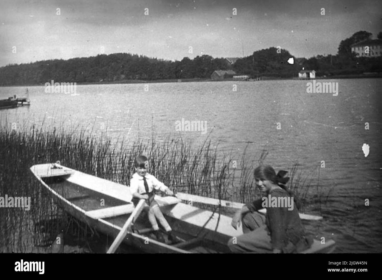 Les frères et sœurs Lithander à Sjöstugan, Lac Rådasjön probablement le garçon Patrick Lithander, qui fait une de ses sœurs plus âgées sur le Lac Rådasjön en dessous de Sjöstugan. Ici vécu par la famille Lithander occasionnellement pendant la première moitié du siècle 20th.Sjöstugan était un pavillon de chasse qui faisait partie de la propriété du Lithander. Il y avait aussi une plus grande maison pour l'hébergement toute l'année. Banque D'Images