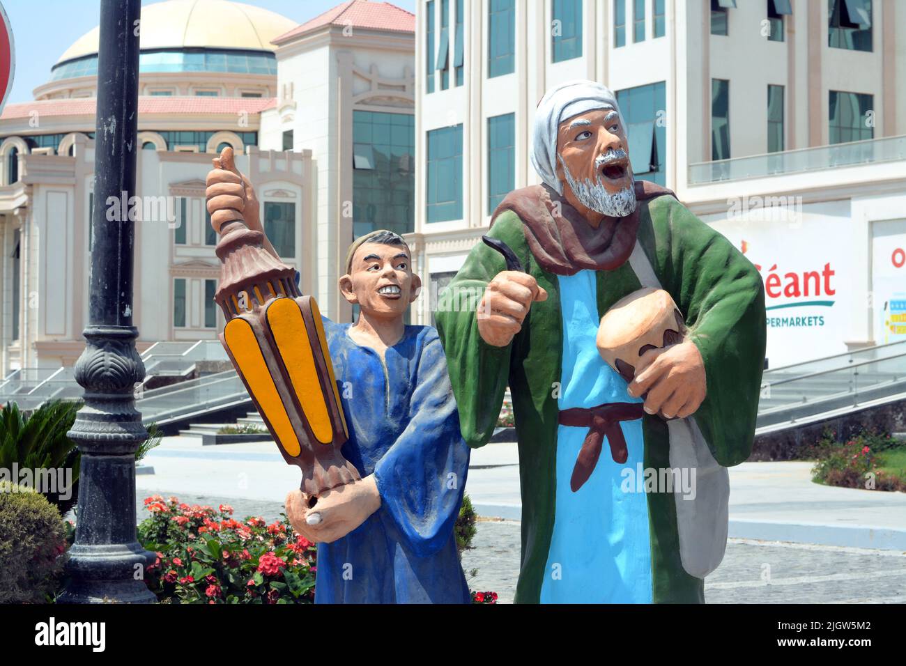 Le Caire, l'Egypte, 6 juin 2022: Un mesaharati et un enfant avec une lanterne faneuse islamique sur une décoration du Ramadan dans la rue, il est une personne qui se réveille oth Banque D'Images