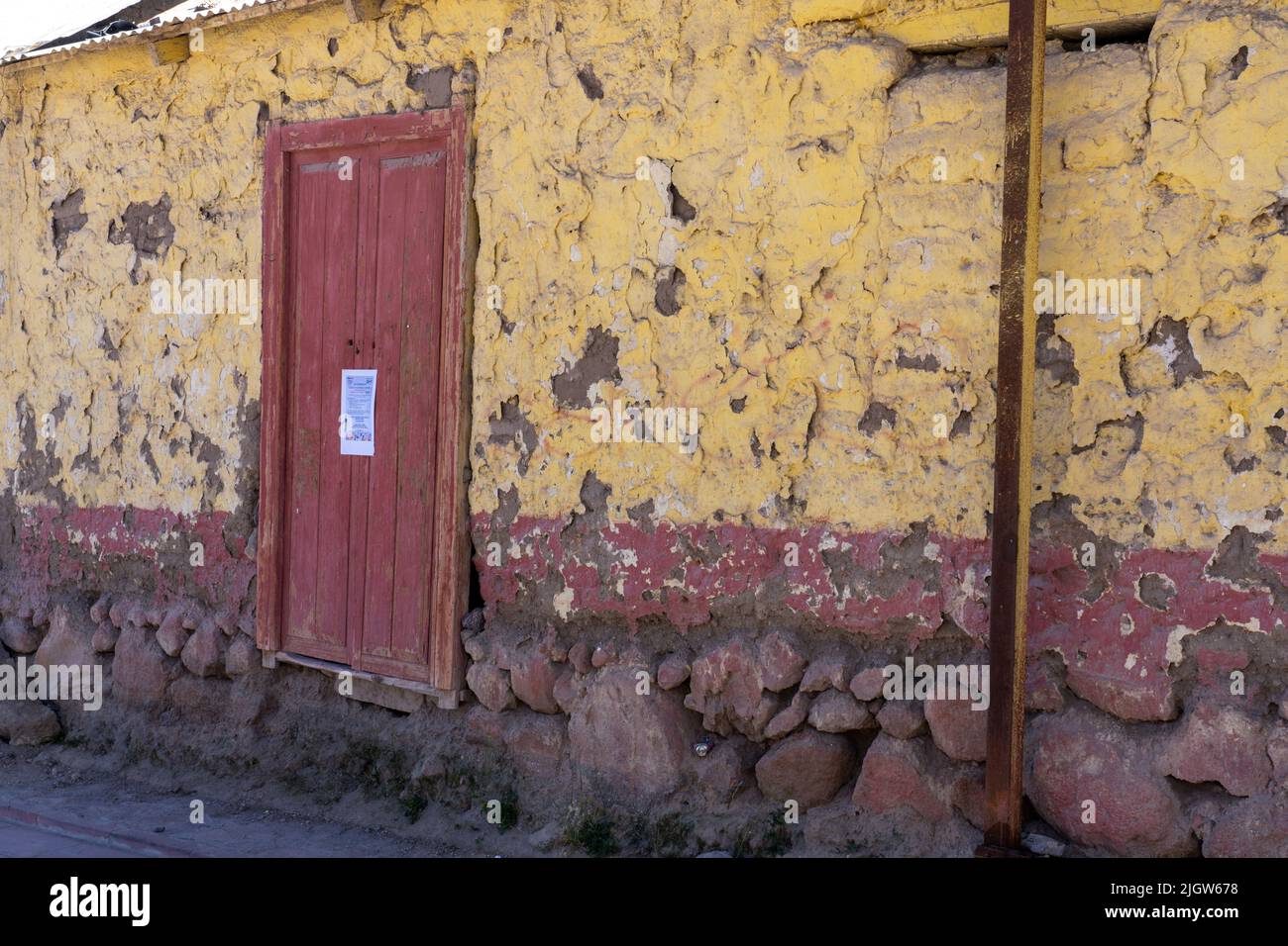 Un bâtiment délabré de construction traditionnelle andine avec peinture écaillée et décolorée dans la ville touristique de Putre, au Chili. Banque D'Images