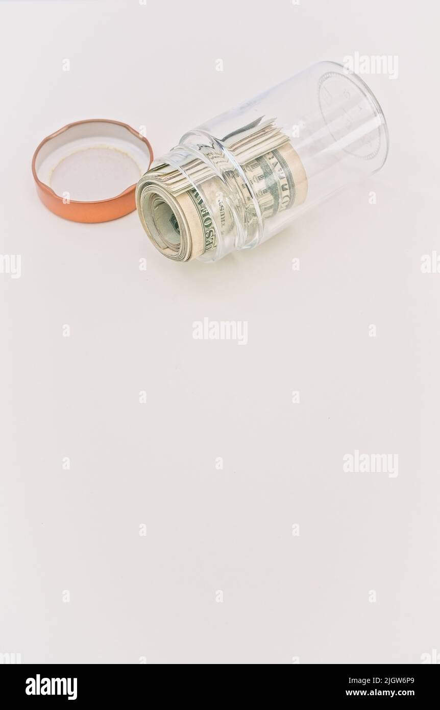 rouleau d'argent dans un pot en verre sur un bureau blanc lumineux avec espace de copie - concept économique Banque D'Images