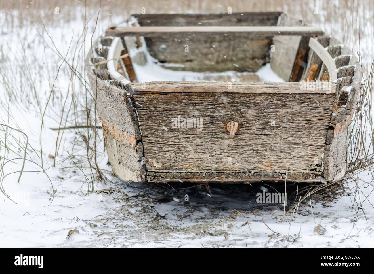Bateau de pêche amarré en bois sur la rive du Danube affluent en eau gelée. Banque D'Images