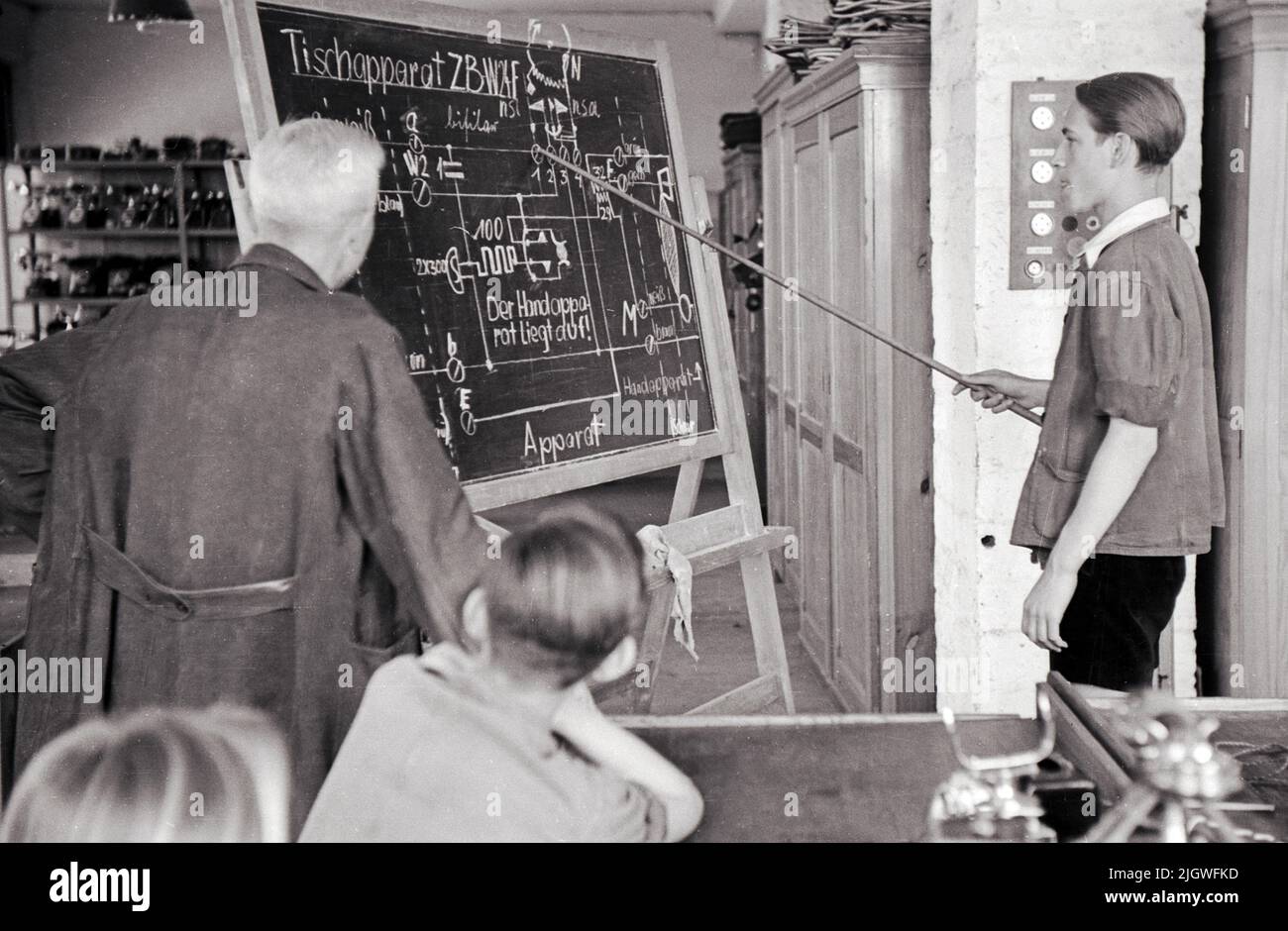 Original-Bildunterschift: Fernmelde- und Telegrafenbau-Lehrlinge auf der Schulbank: Lehrlinge verfolgen die Stromläufe eines Tischfernsprachers, die von ihnen selbst gezeichnet wurden, Berlin, Allemagne 1947. Banque D'Images